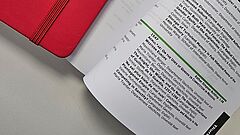 Notizbuch und aufgeschlagenes Programmheft 
