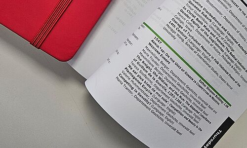 Notizbuch und aufgeschlagenes Programmheft 
