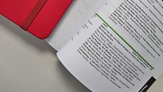 Notizbuch und aufgeschlagenes Programmheft 