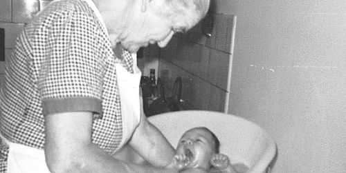 Hebamme badet Baby
